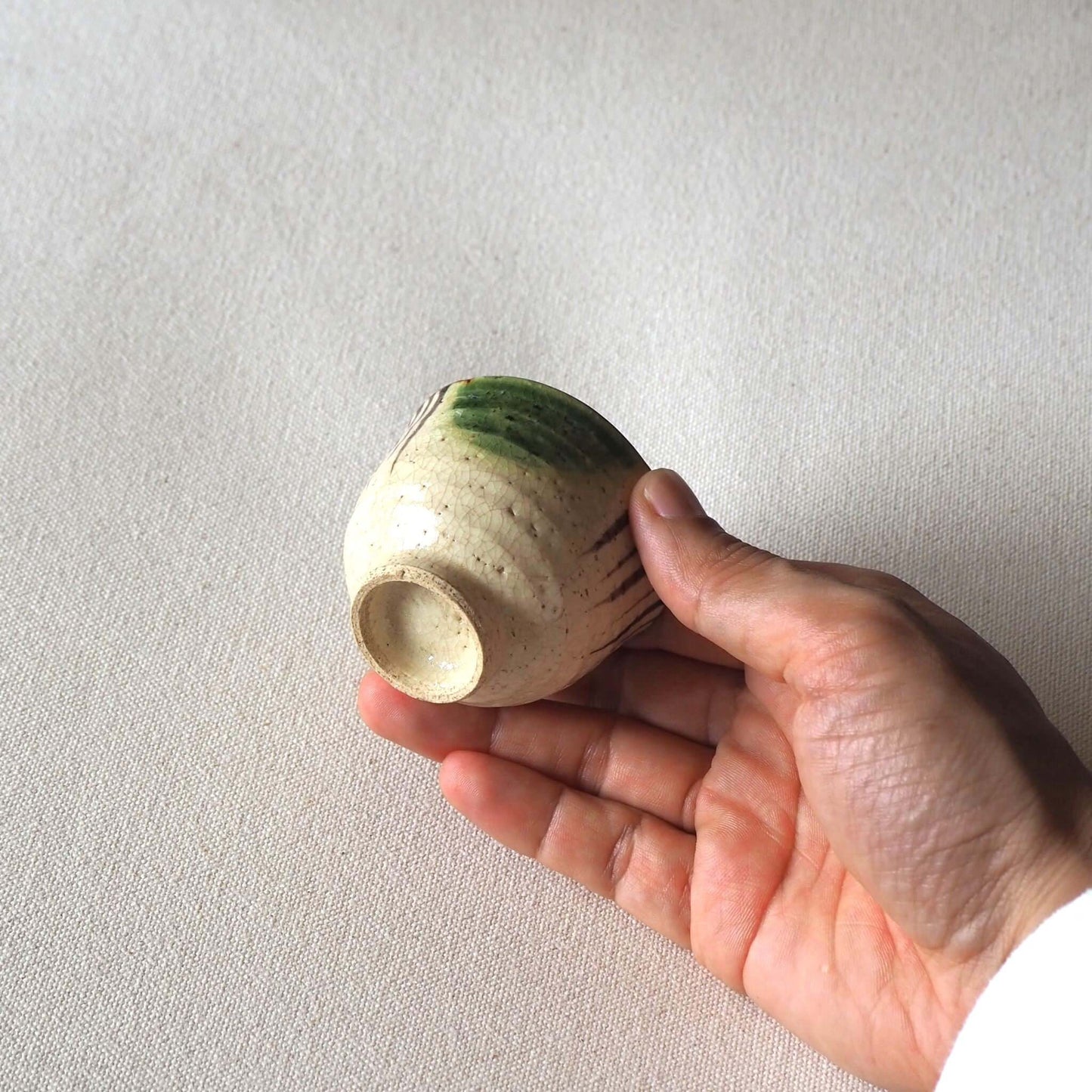 織部煎茶杯を手で持っている