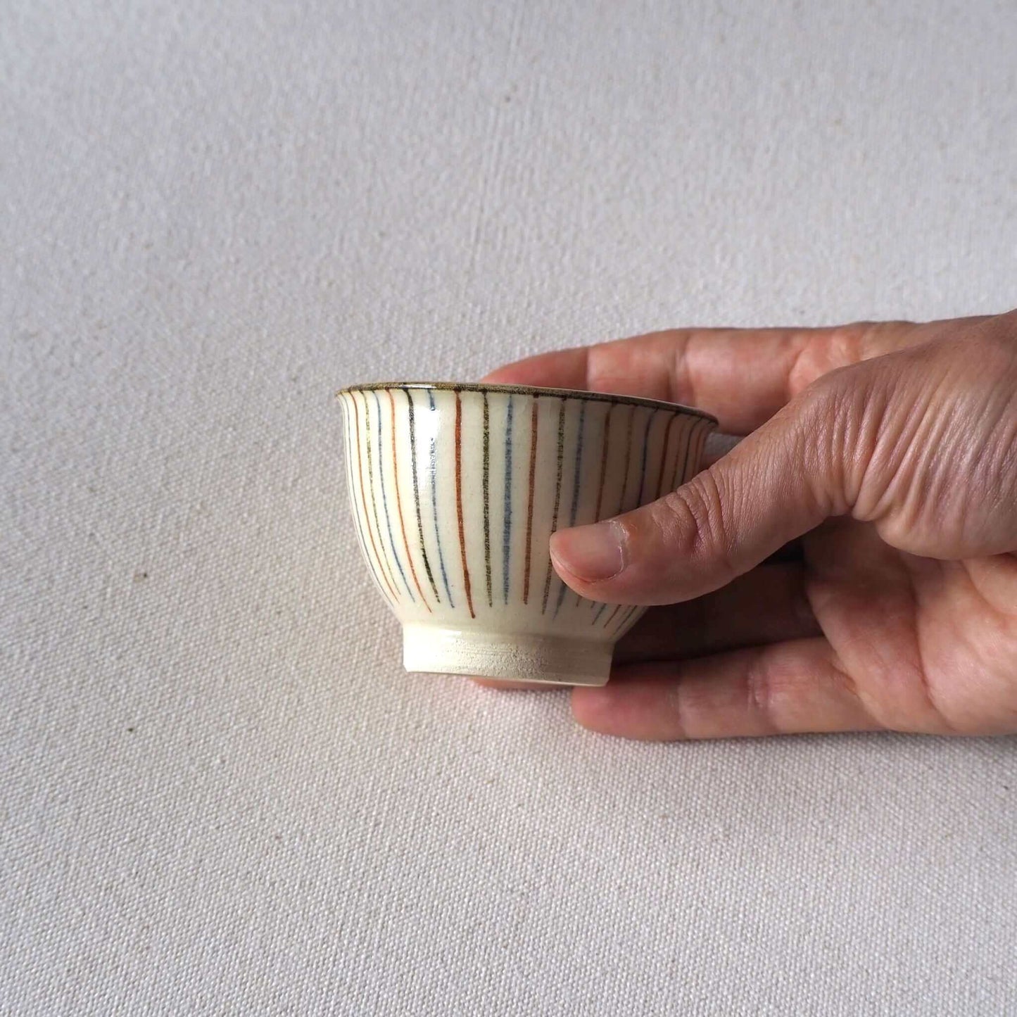 京焼麦藁手煎茶碗を手で持った写真