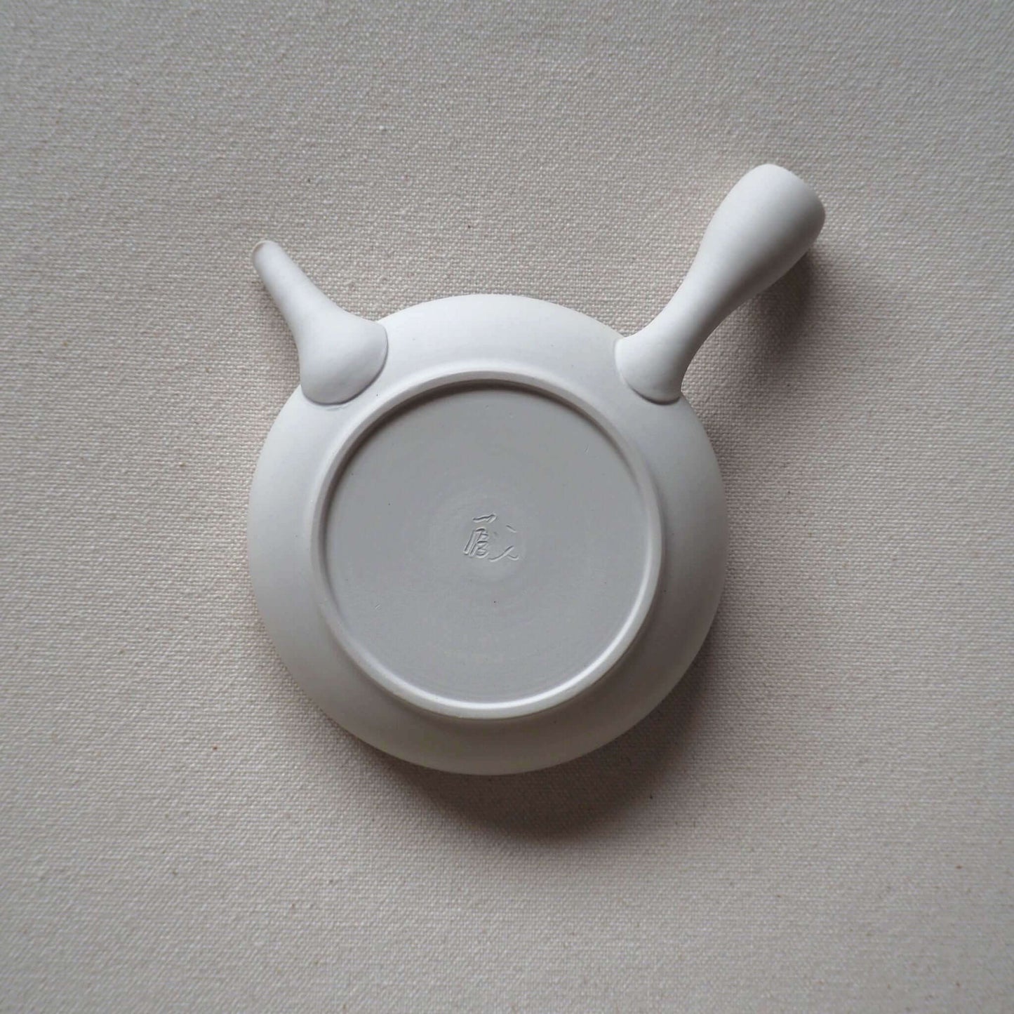 常滑焼前川淳蔵の白極平急須を裏返した状態の写真