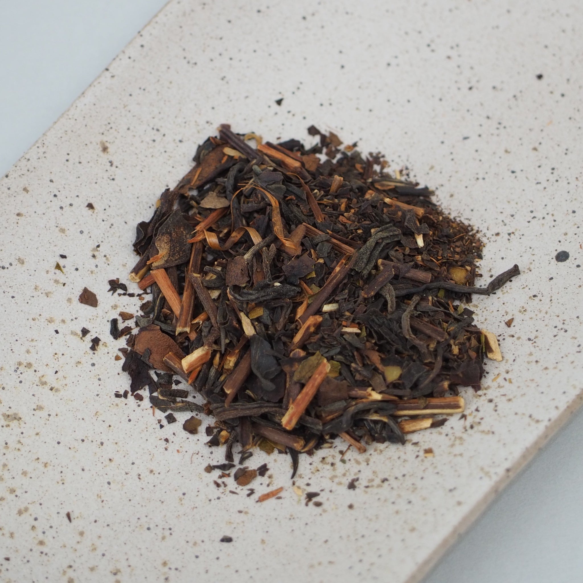 和紅茶の焙じ紅茶の茶葉画像です。一般的な紅茶よりも、茶葉は少し大きめにカットされていて、茶葉は濃い茶色、茎は薄い茶色です。