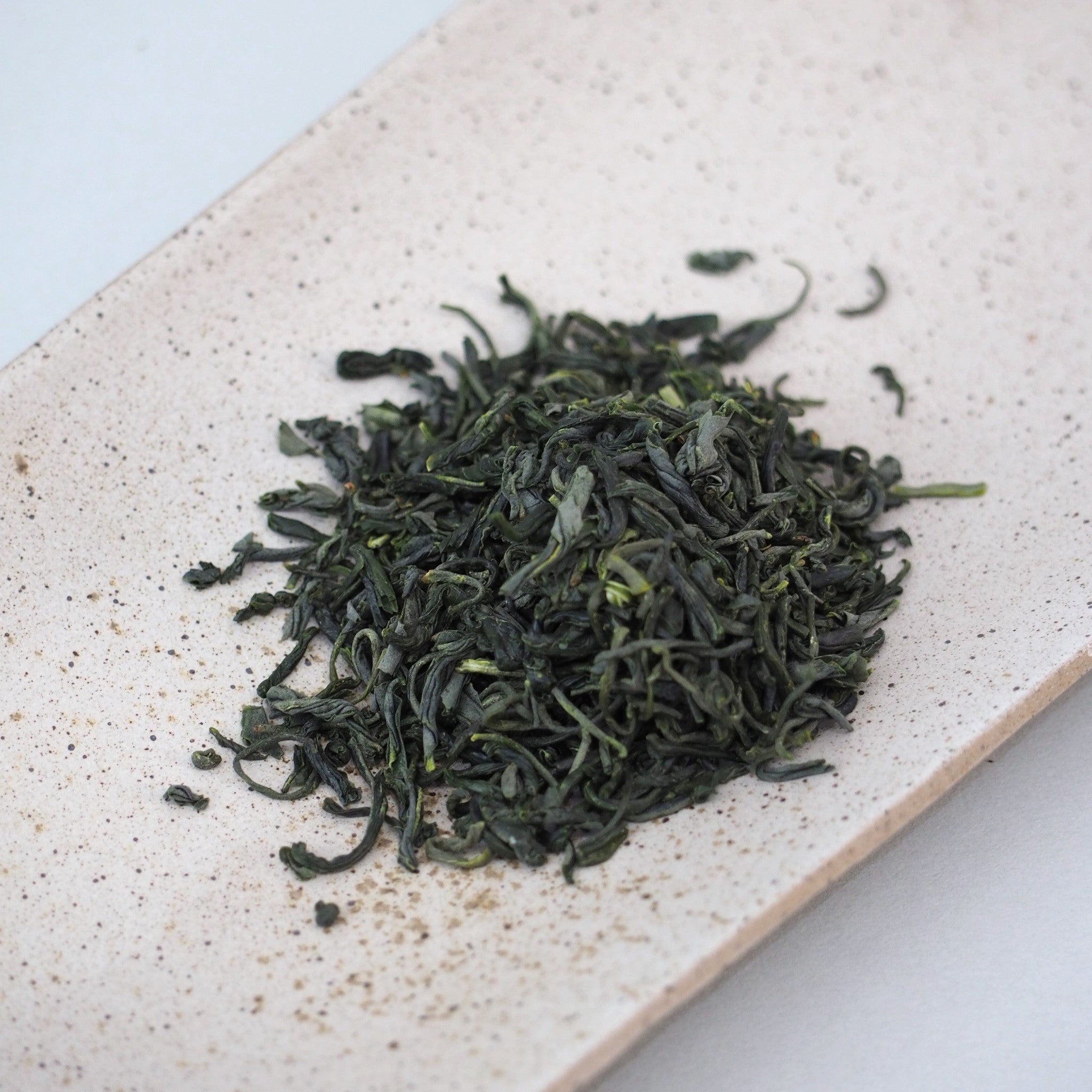 高千穂釜炒り茶の茶葉画像です。茶葉の色は深い緑色、茶葉の形状は少し捩れています。