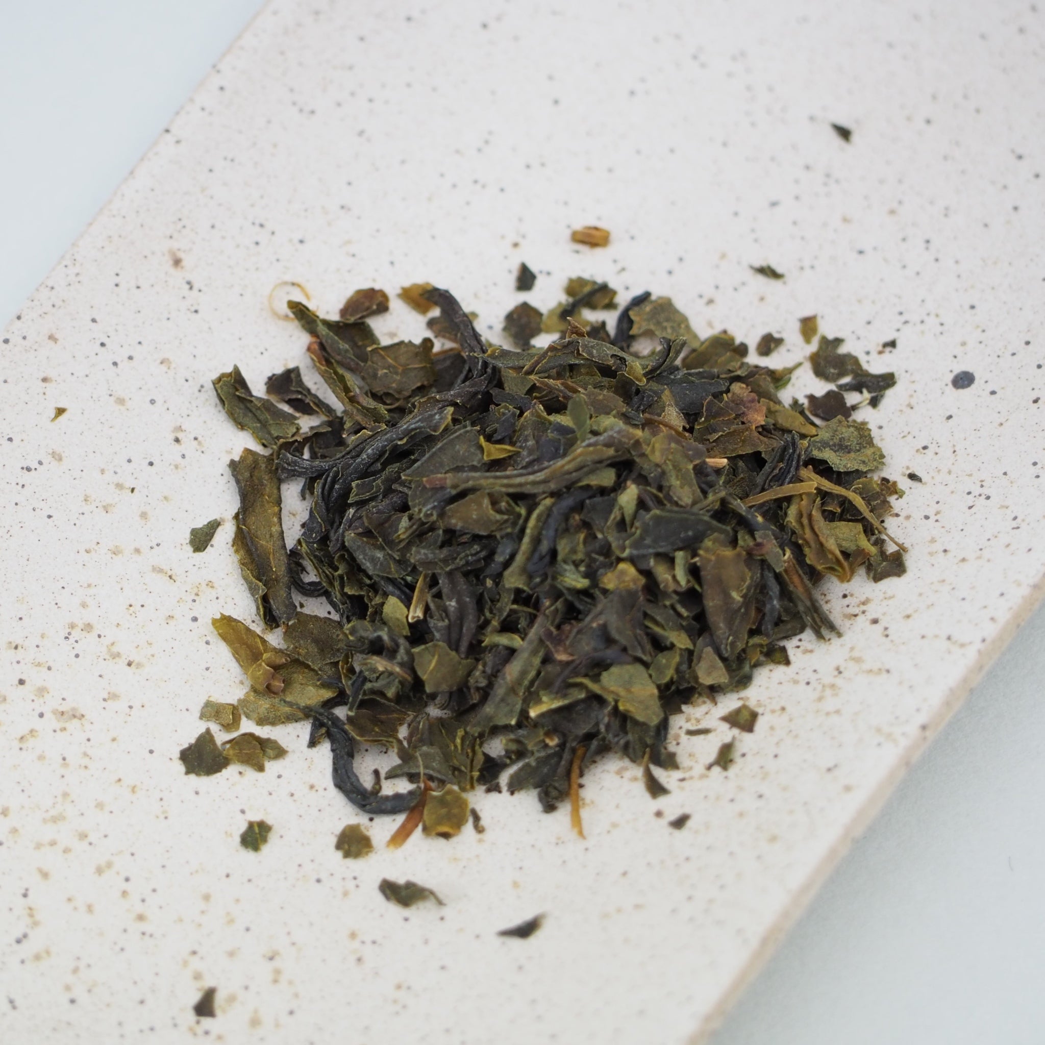 国産釜炒り茶佐護茶の茶葉画像です。茶葉は少し茶色がかった緑で、乾いた昆布の色に似ています。