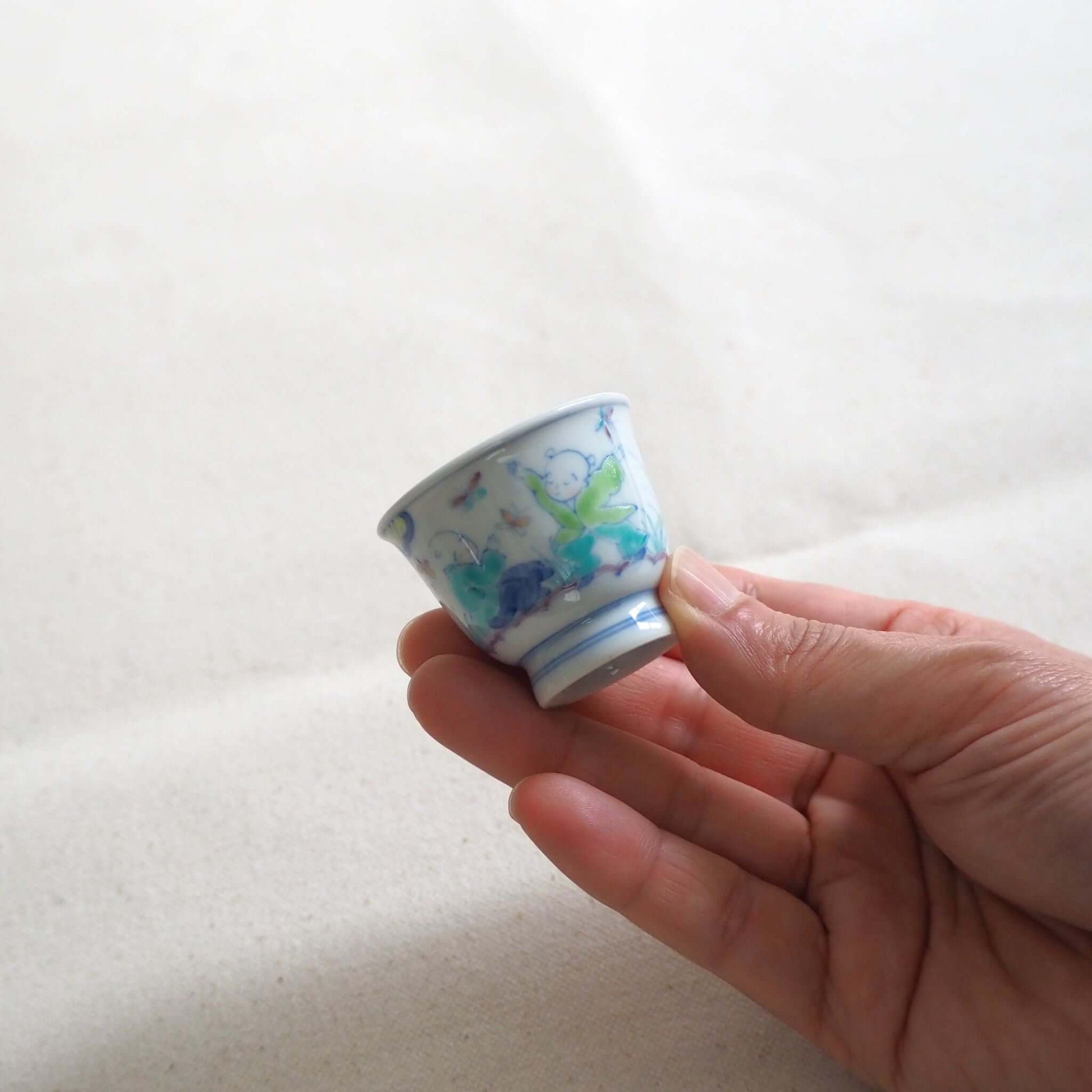 京焼 昭阿弥作 淡彩唐子煎茶杯 手描き唐子文様 伝統工芸 京都陶器　手で持っている