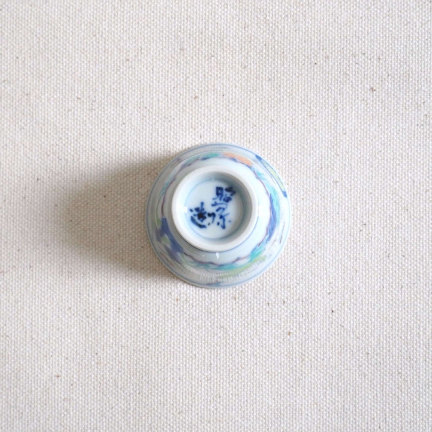 京焼 昭阿弥作 淡彩唐子煎茶杯 手描き唐子文様 伝統工芸 京都陶器　裏返して底を見ている