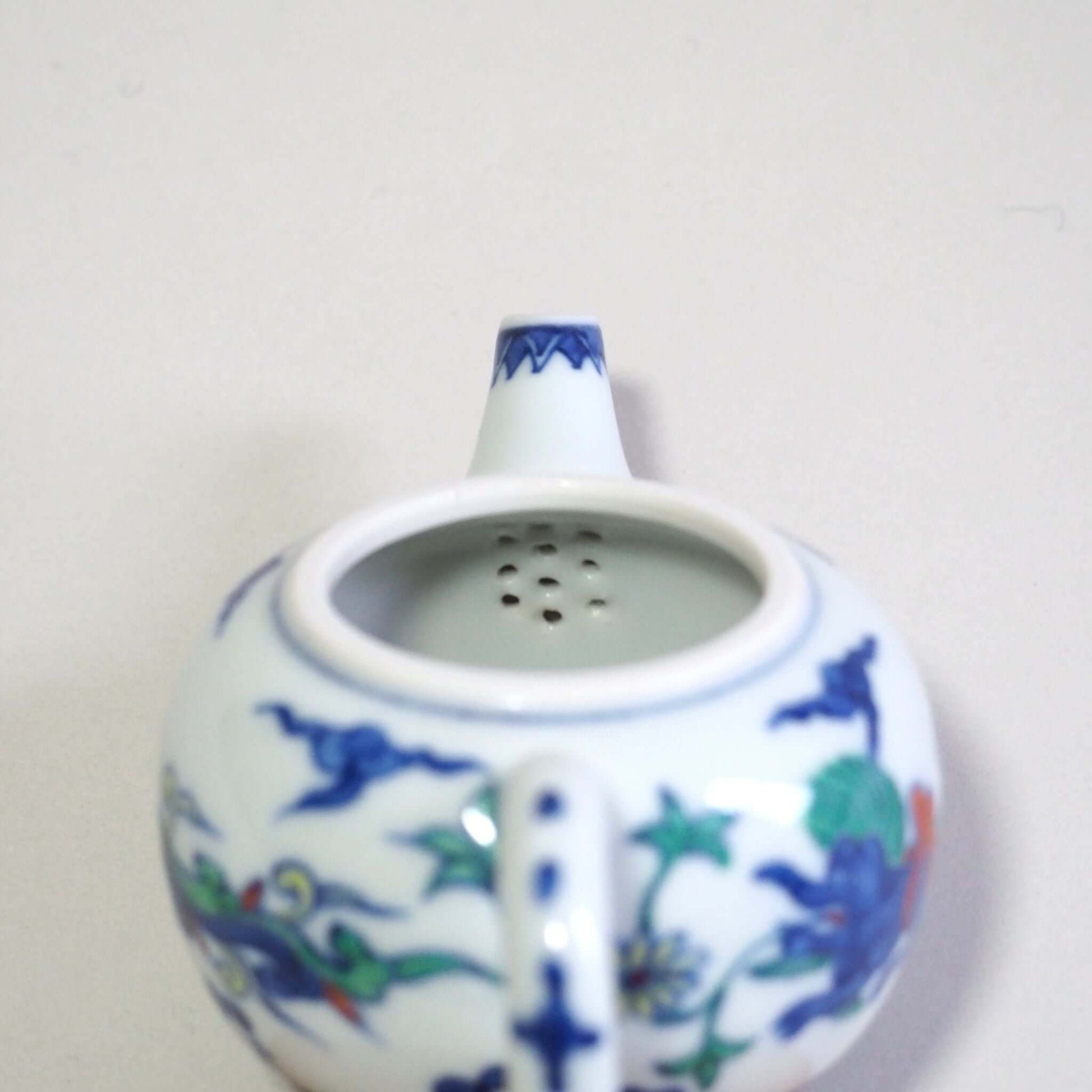 Looking at the tea strainer inside a Kyo-yaki teapot with a colorful dragon design by Shoami.