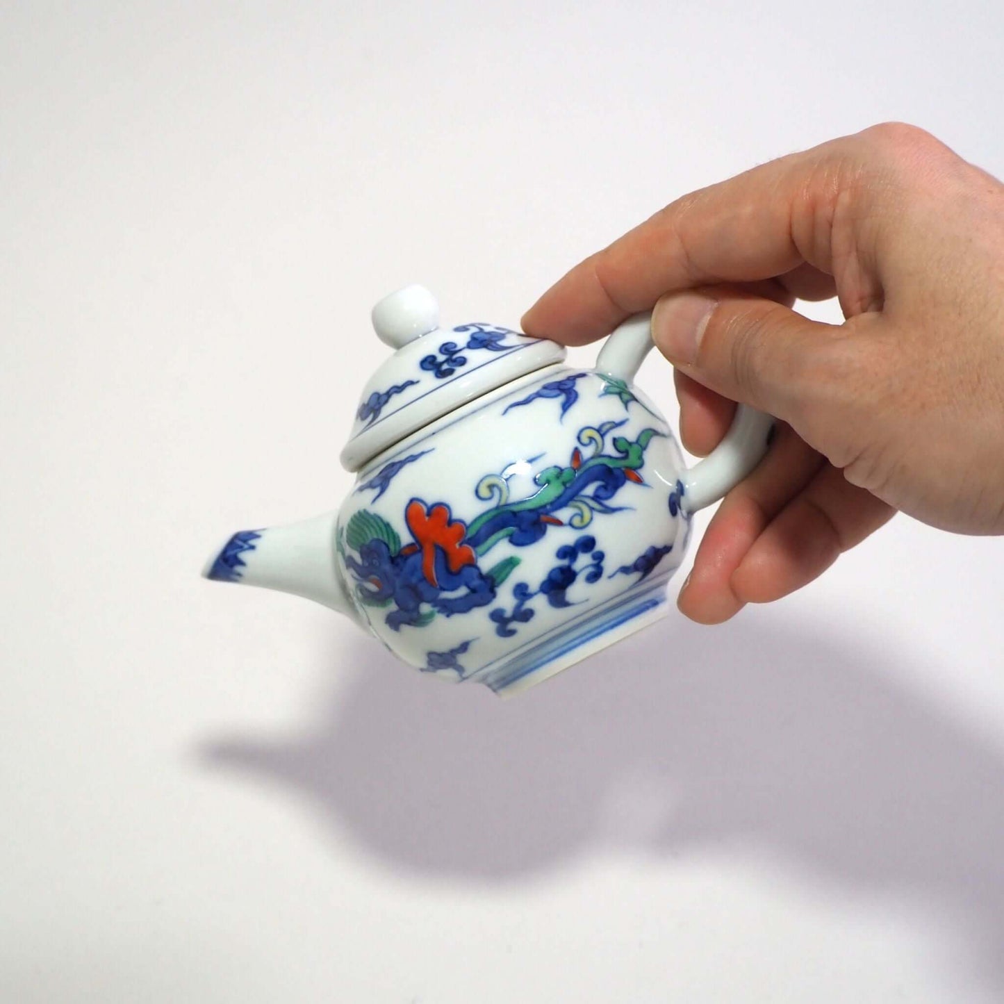 He is holding a Kyo-yaki teapot with a colorful dragon design by Shoami.