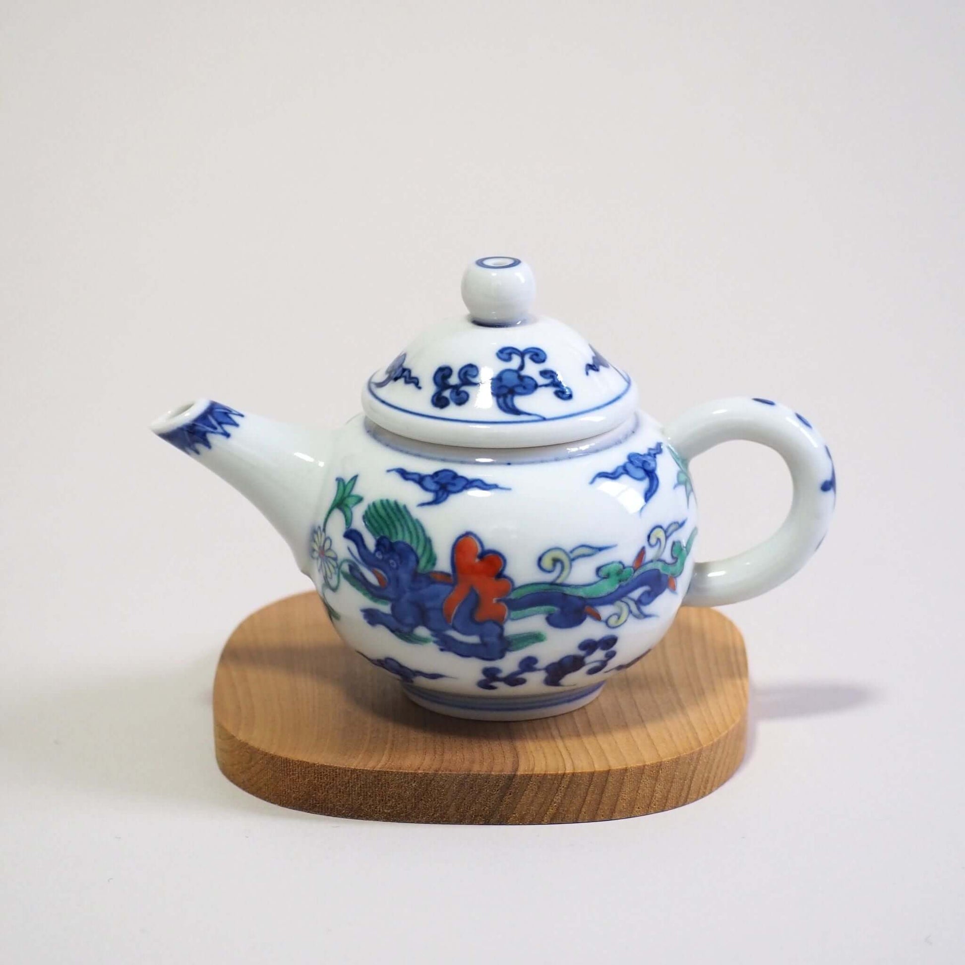 Looking at the side of the body of a Kyo-yaki teapot with a colorful dragon design by Shoami.