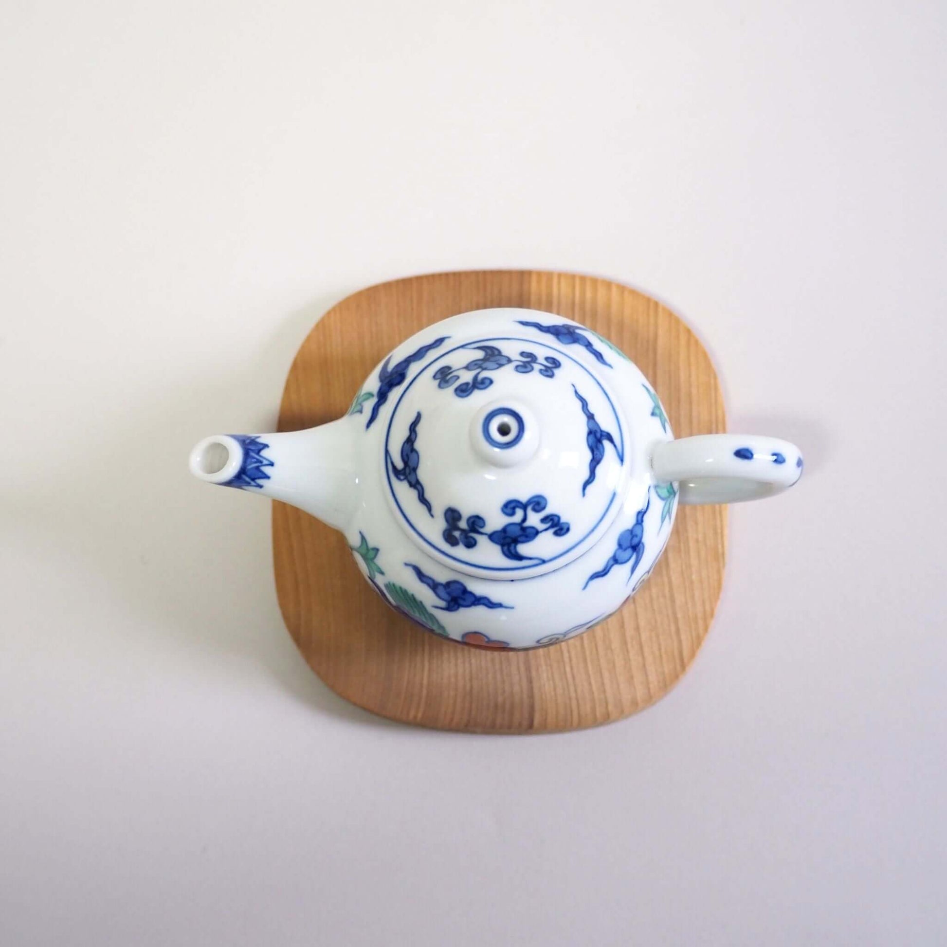 A Kyo-yaki teapot with a colorful dragon design by Shoami, viewed from directly above.