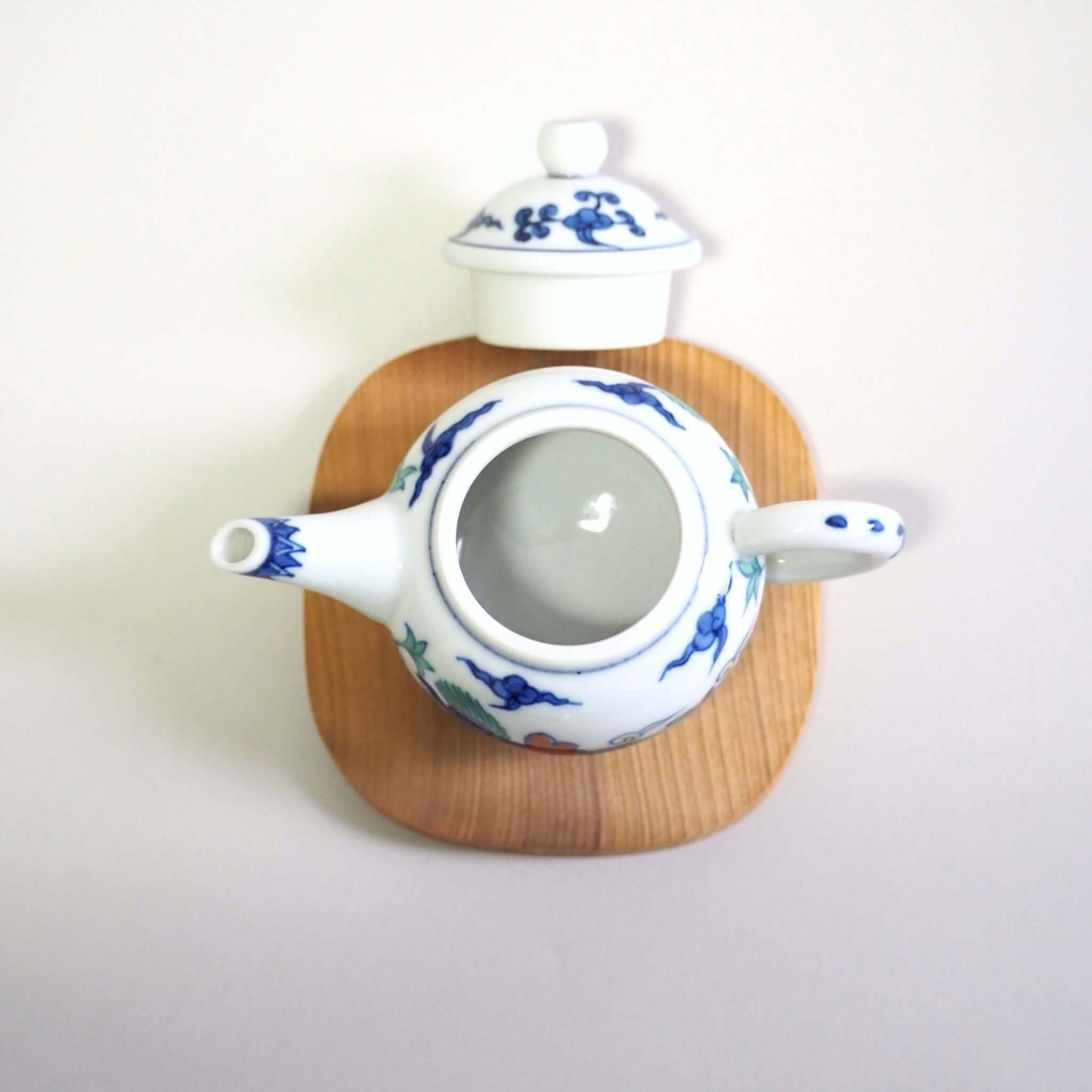 The lid of a Kyo-yaki teapot with a colorful dragon design by Shoami has been removed and it is being viewed from directly above.