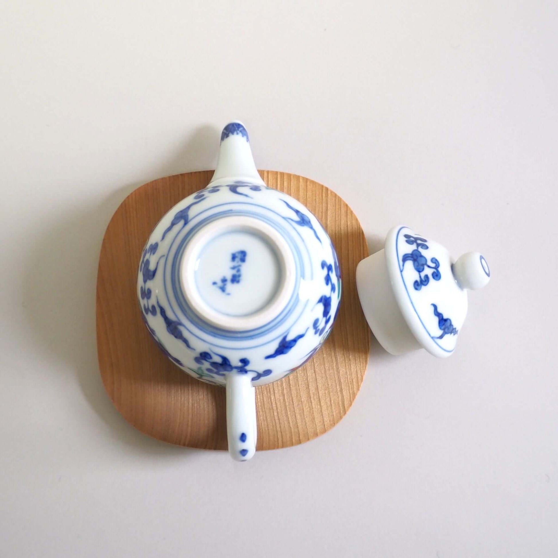 The lid of a Kyo-yaki teapot with a colorful dragon design by Shoami has been removed and turned over, looking from directly above.