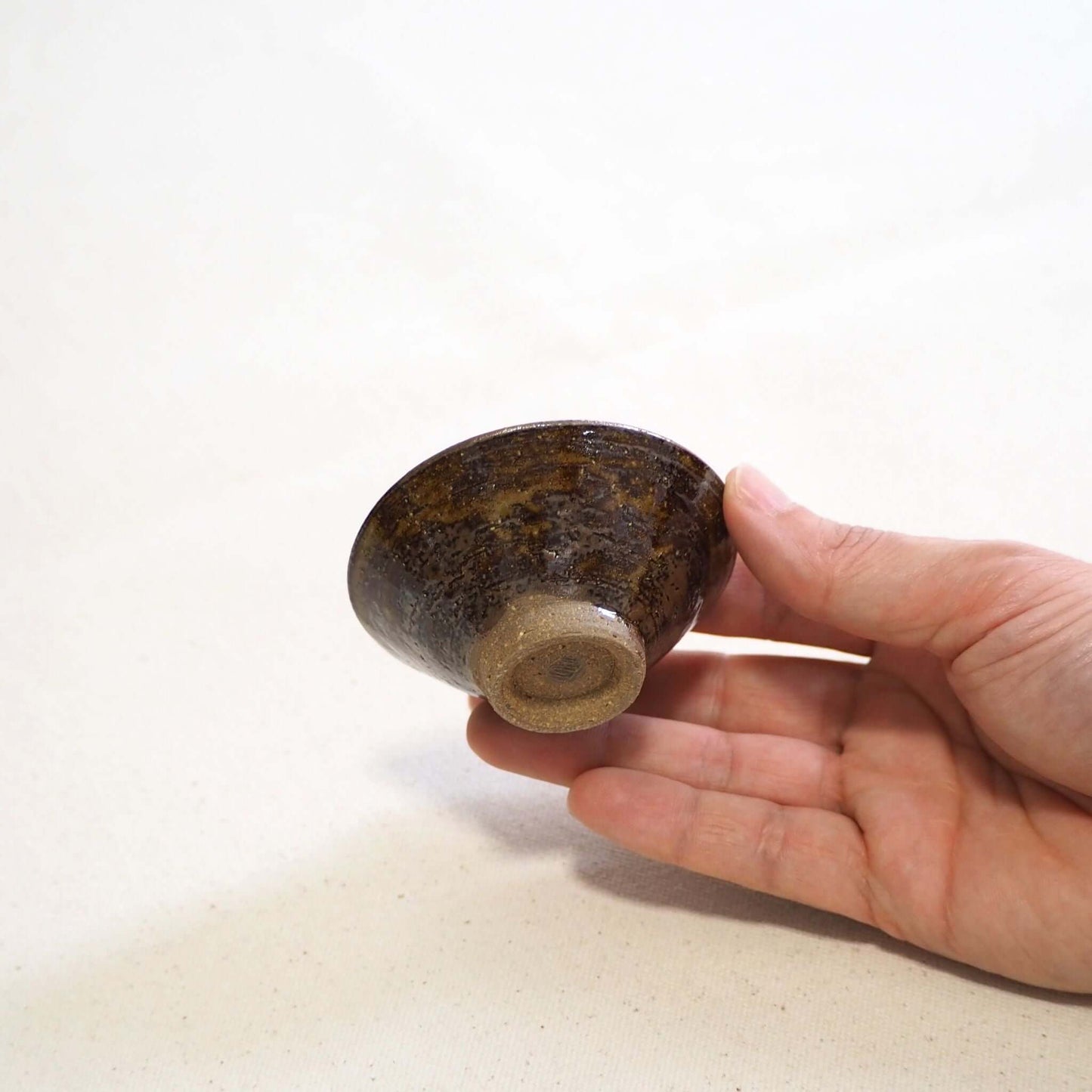 京焼 石雲窯作 飴釉茶杯 手持ちイメージ