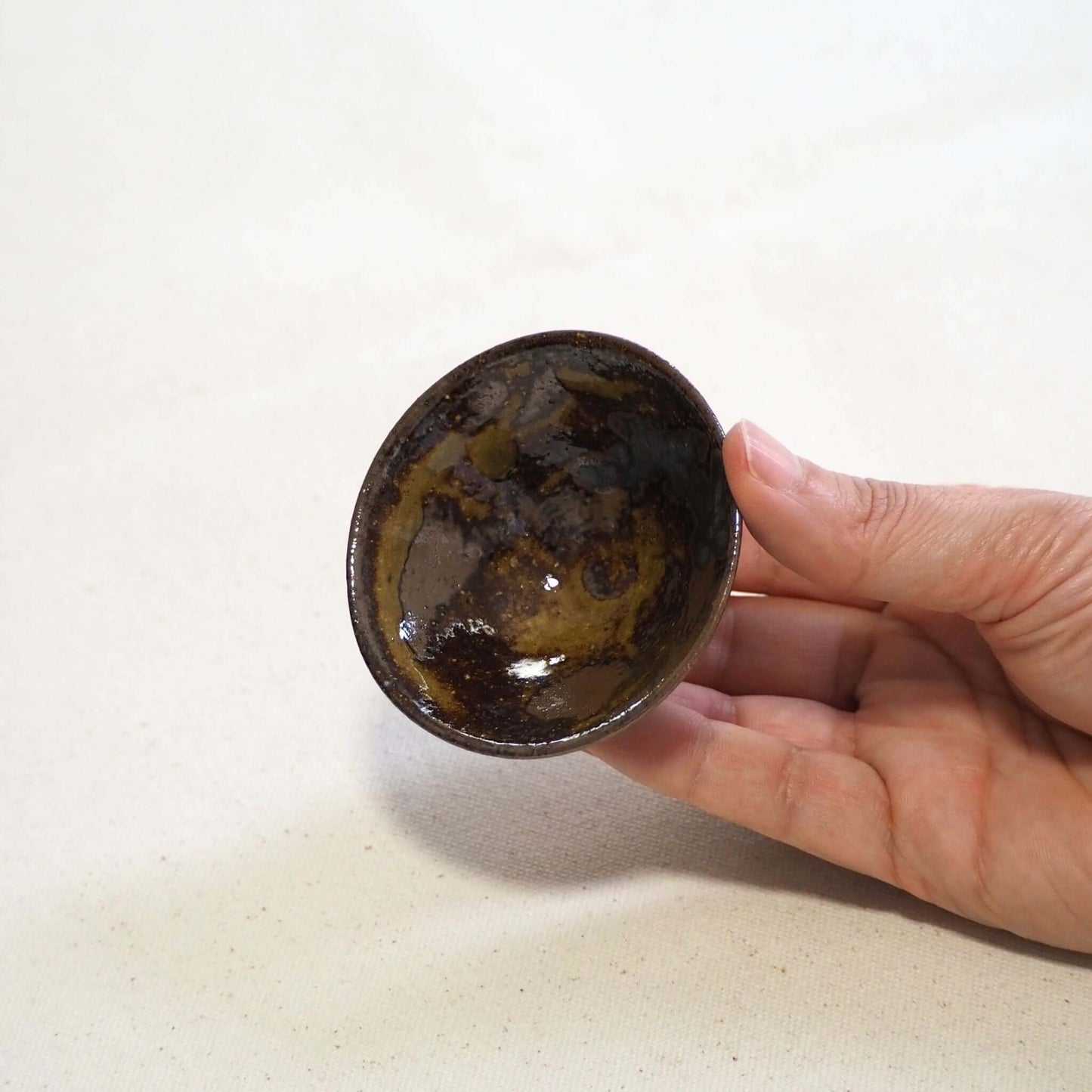 京焼 石雲窯作 飴釉茶杯 手持ちイメージ