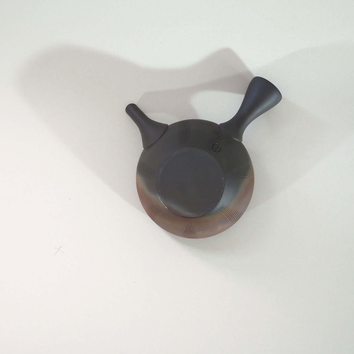常滑焼玉光陶園の窯変平丸急須を裏返し、上方向から見ている