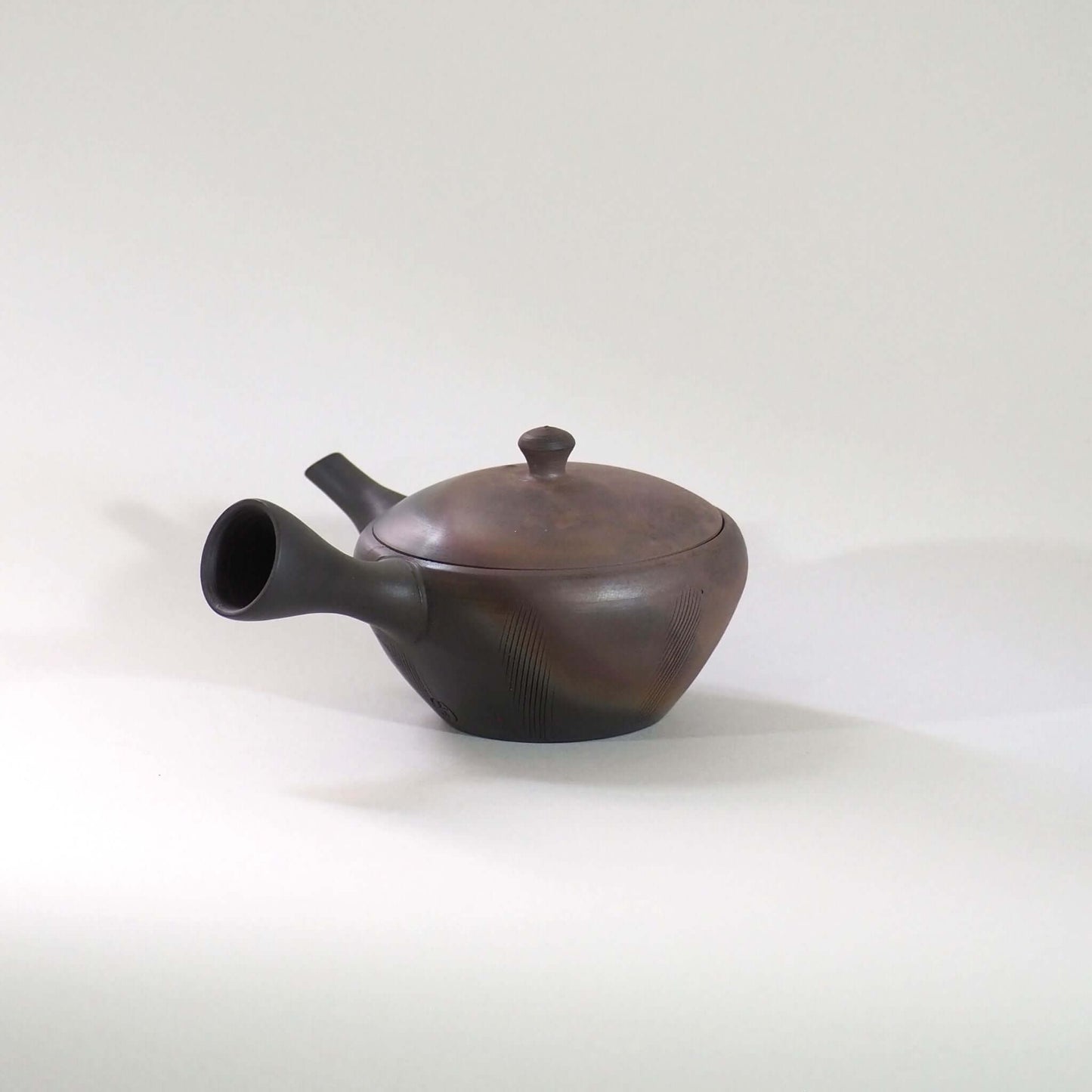 常滑焼玉光陶園の窯変平丸急須の画像。把手が左にある