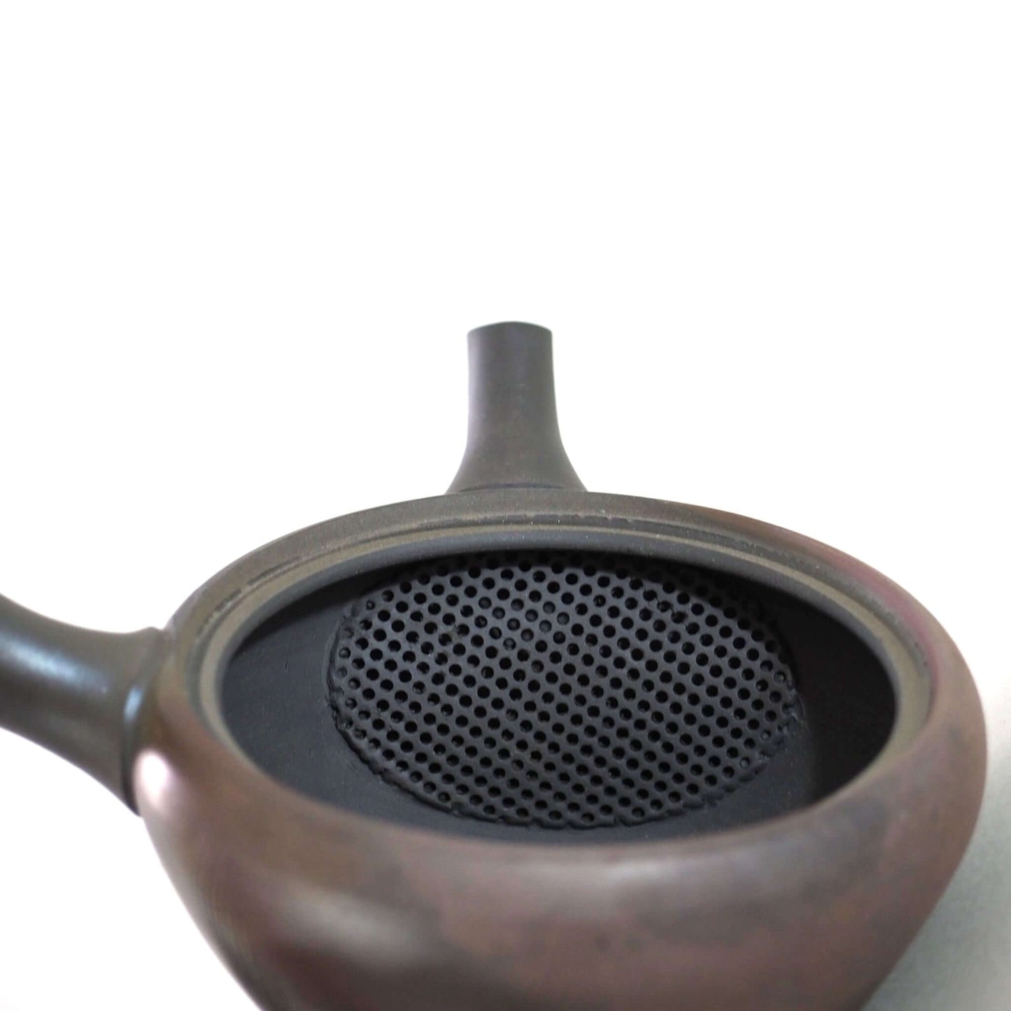 常滑焼玉光陶園の窯変平丸急須の蓋を開け、内側の茶漉しを見ている