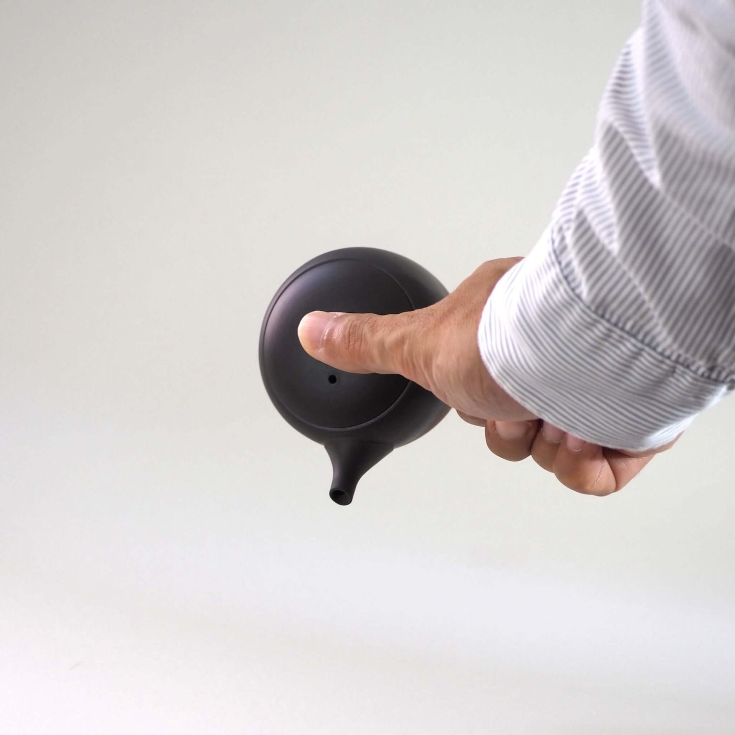 常滑焼玉光陶園の窯変長丸急須の手で持ち傾けている