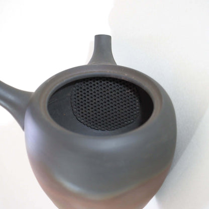 常滑焼玉光陶園の窯変長丸急須の蓋を開け、内側の茶漉しを見ている