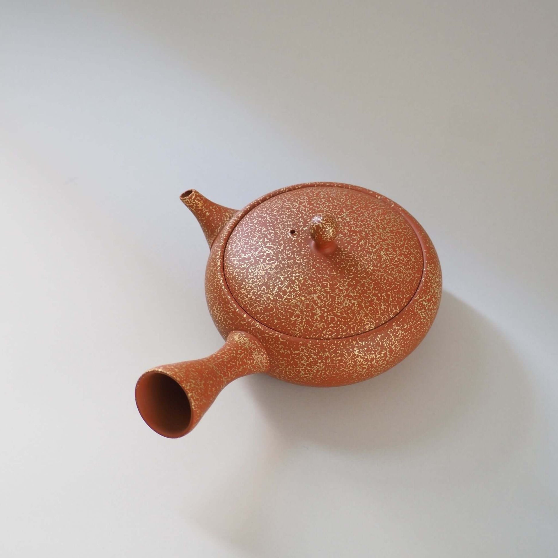 常滑焼玉光陶園の朱泥平丸金たたき急須を斜め上から見ている