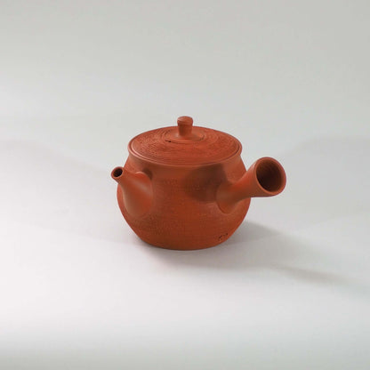 常滑焼玉光陶園の朱泥松皮急須を正面から見ている。注ぎ口が左、把手が右にある