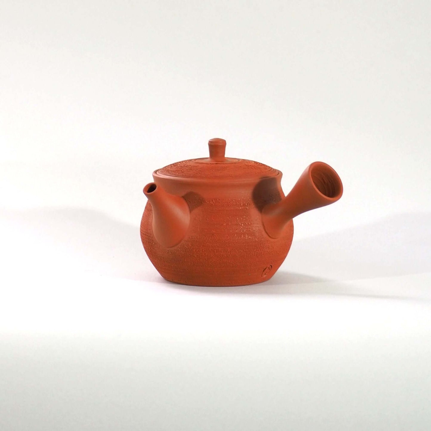 常滑焼玉光陶園の朱泥松皮急須を正面から見ている