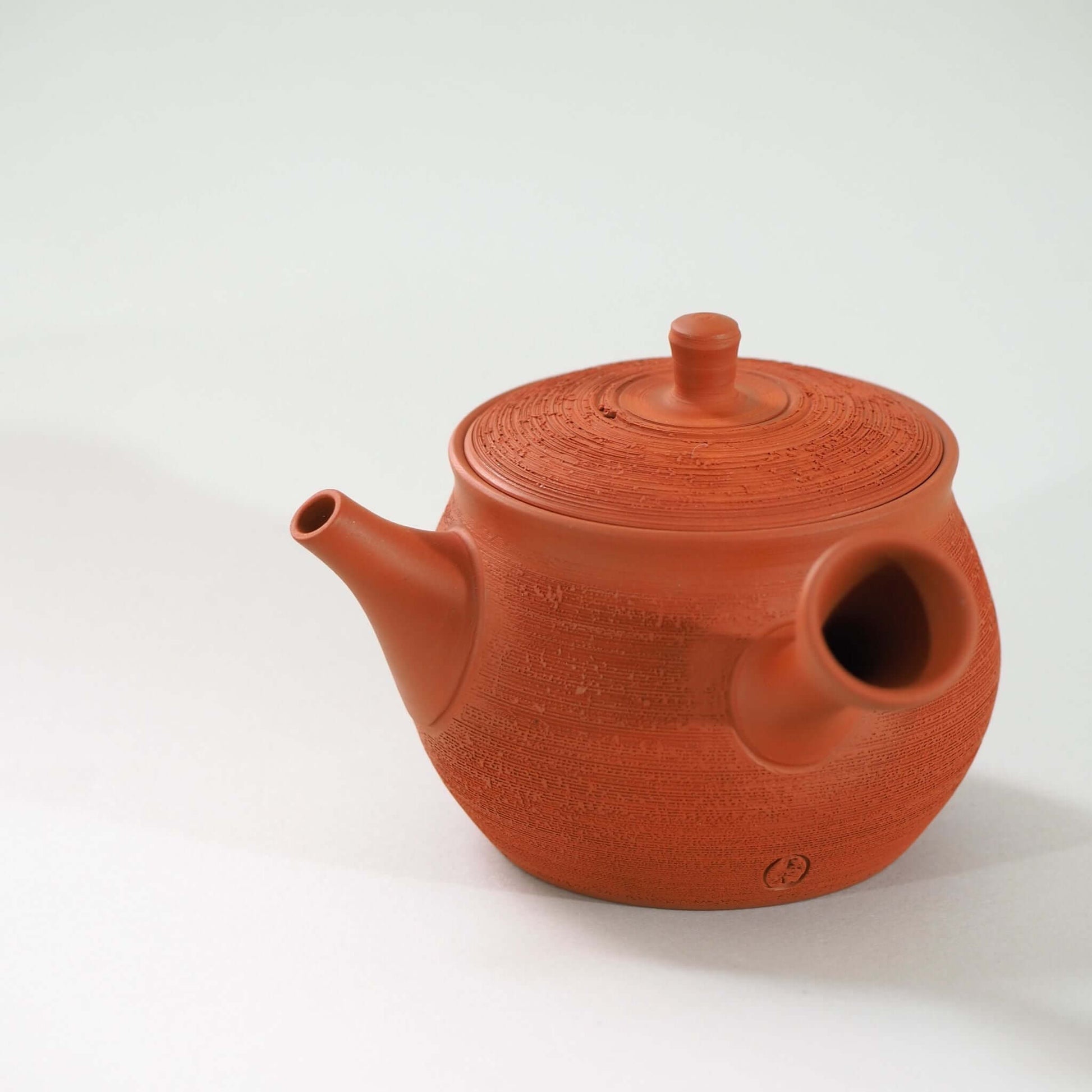 常滑焼玉光陶園の朱泥松皮急須を側面から見ている