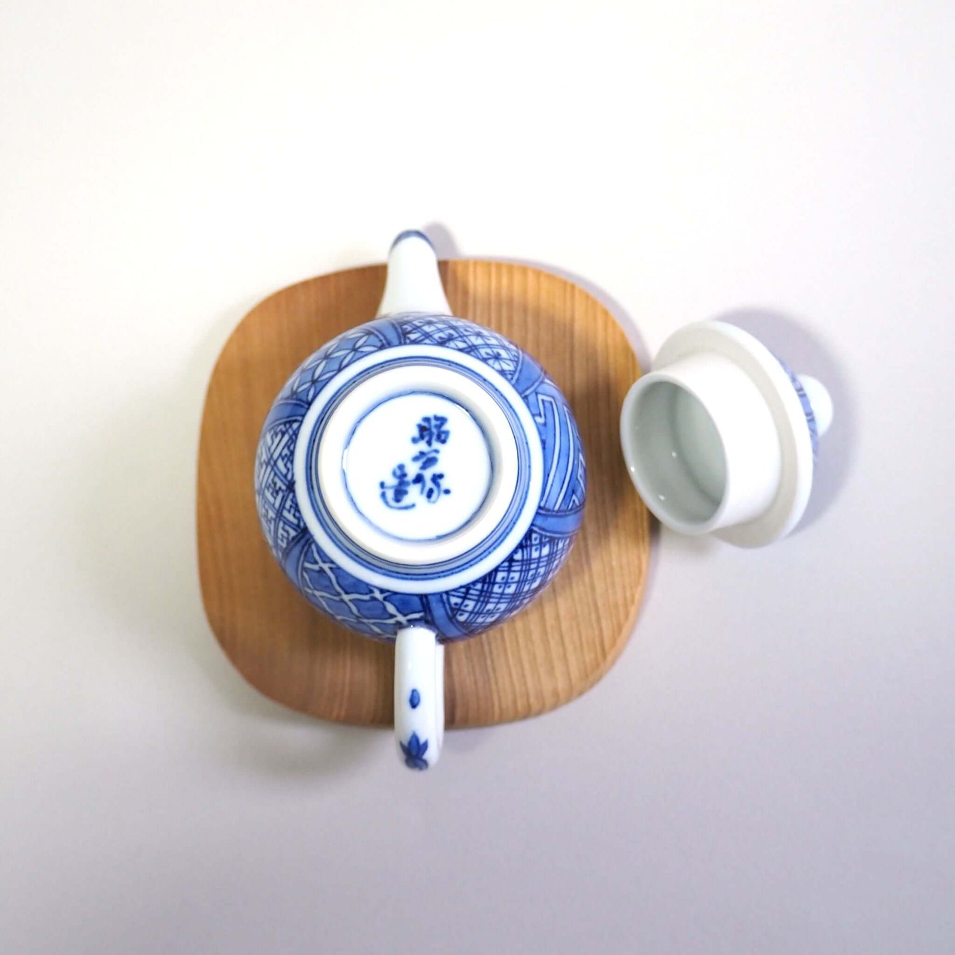 The lid of the Kyoyaki Shoami Sometsuke Shozui teapot is removed, turned over, and viewed from directly above.