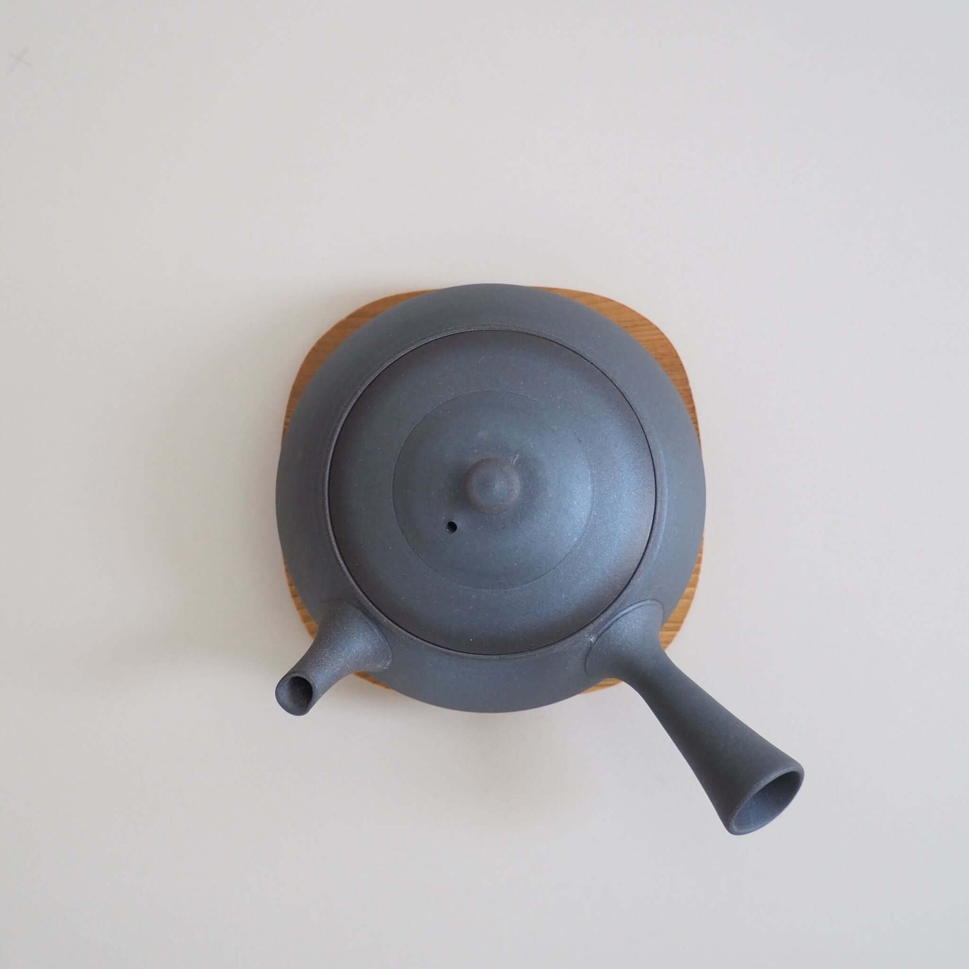 A top view of Tokoname ware potter Tokuta Fujita's black triangular flat teapot