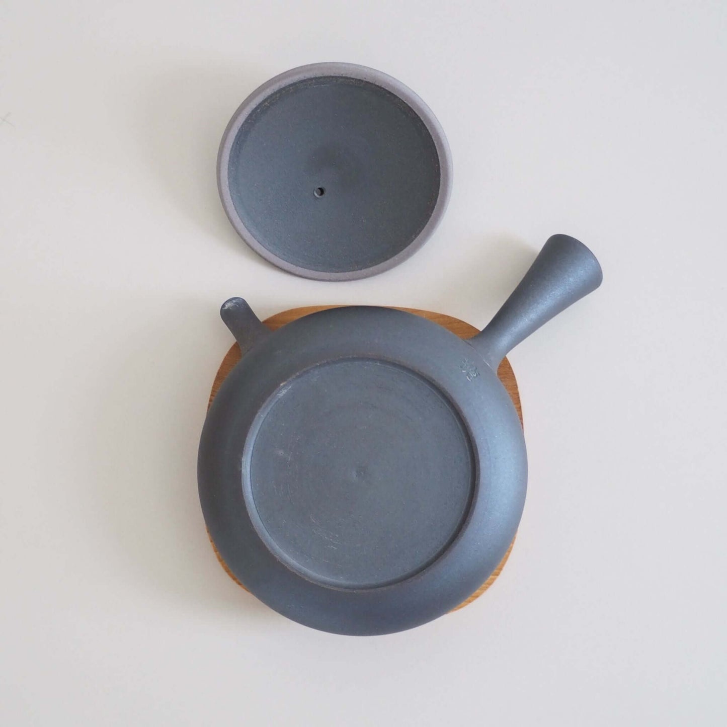 Tokoname pottery artist Tokuta Fujita's black triangular flat teapot is turned over and viewed from above.