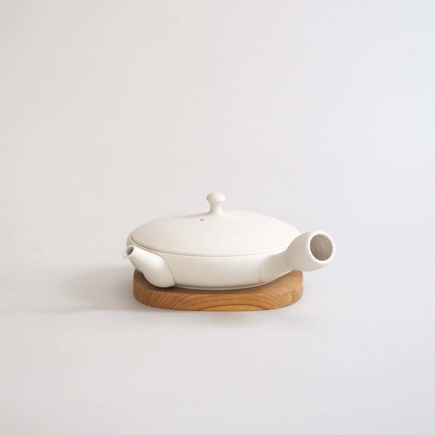Tokoname ware white flat teapot, overall front view — a marble-like white color that is a mix of cream and gray.