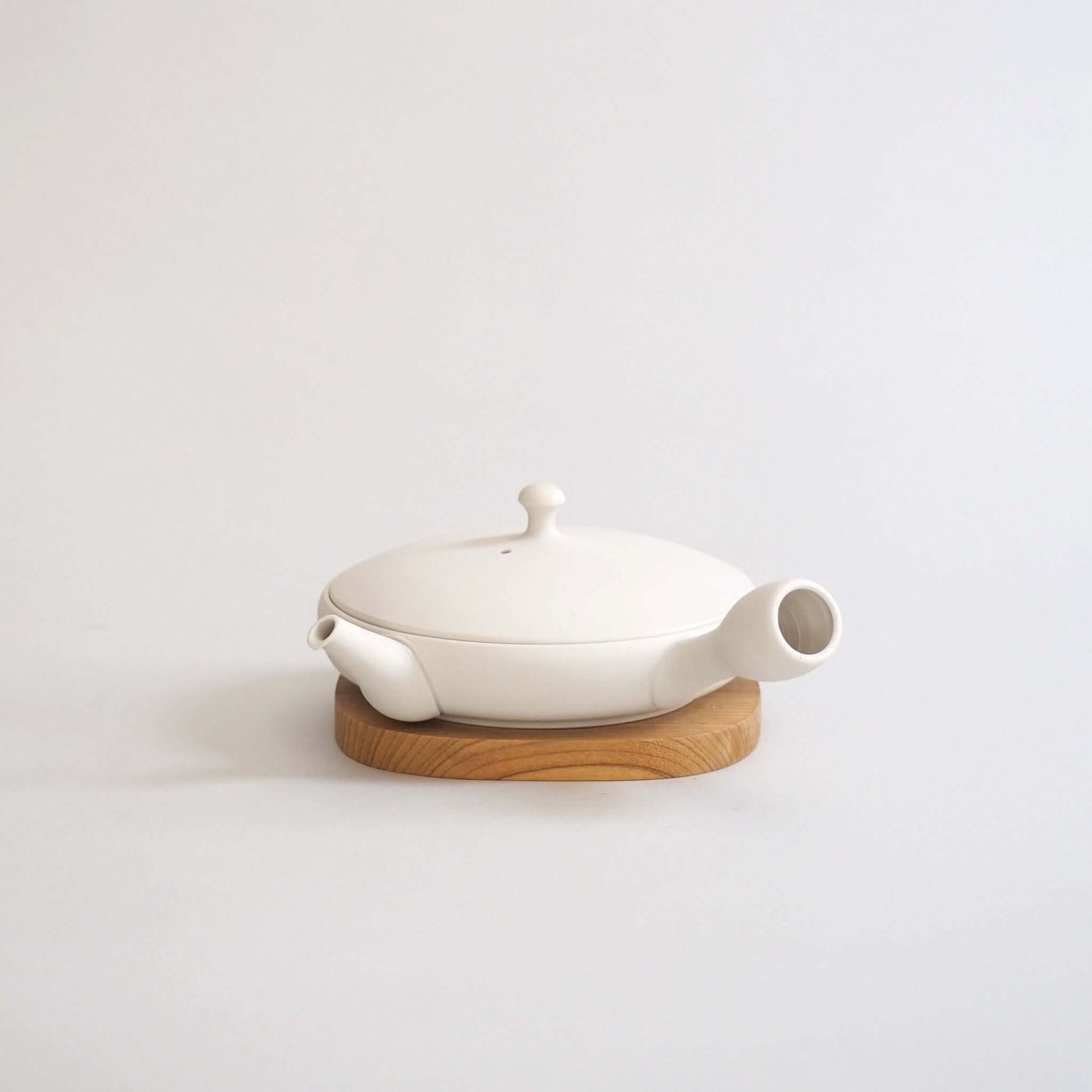 Tokoname ware white flat teapot, overall front view — a marble-like white color that is a mix of cream and gray.