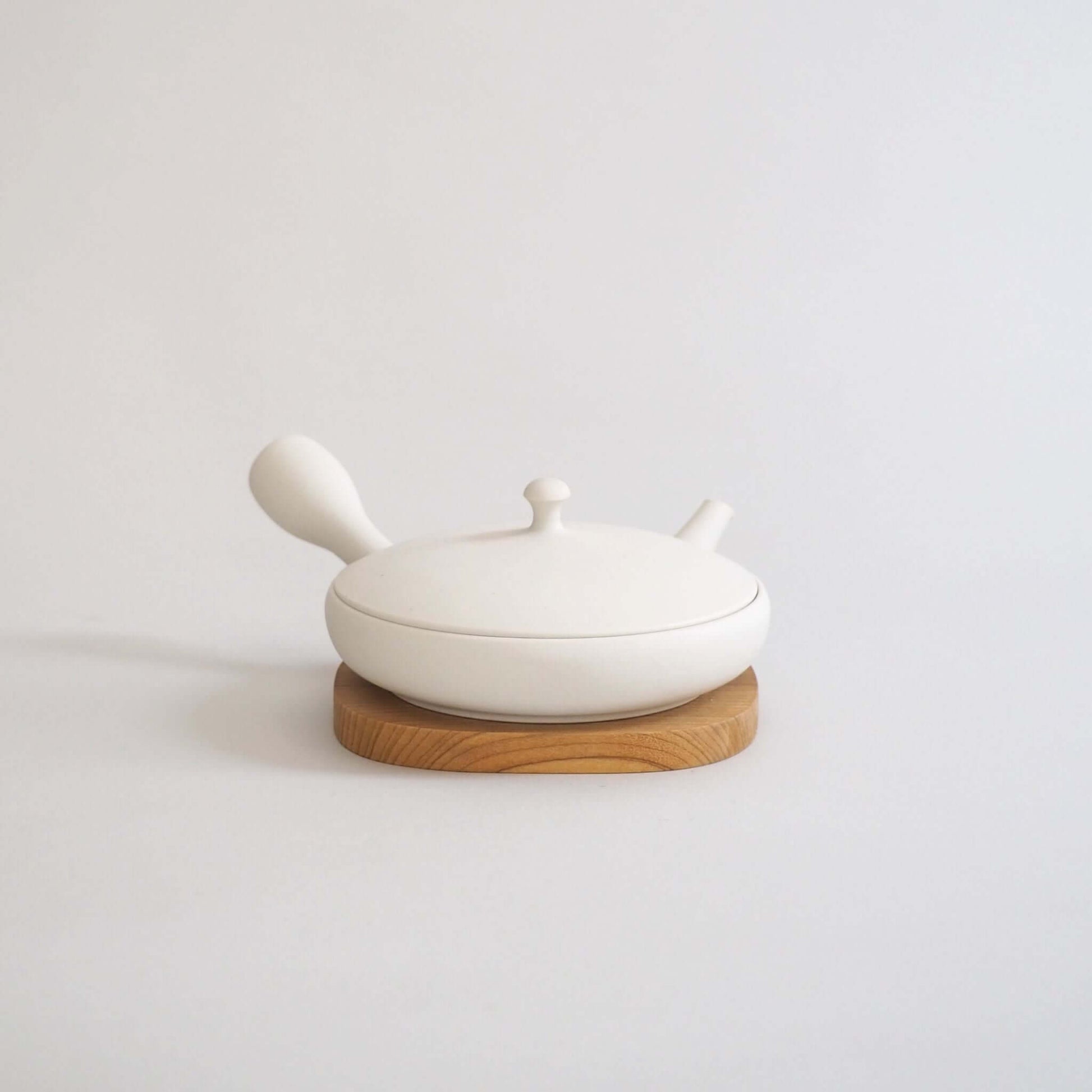 Tokoname ware white flat teapot, overall front view — a marble-like white color that is a mix of cream and gray.