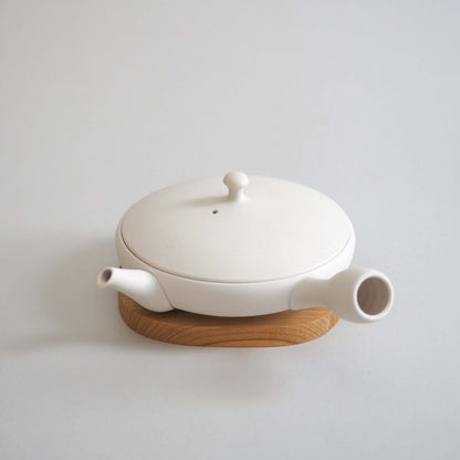 Tokoname ware white flat teapot, viewed from a diagonal angle above — flat form and white color of the lid