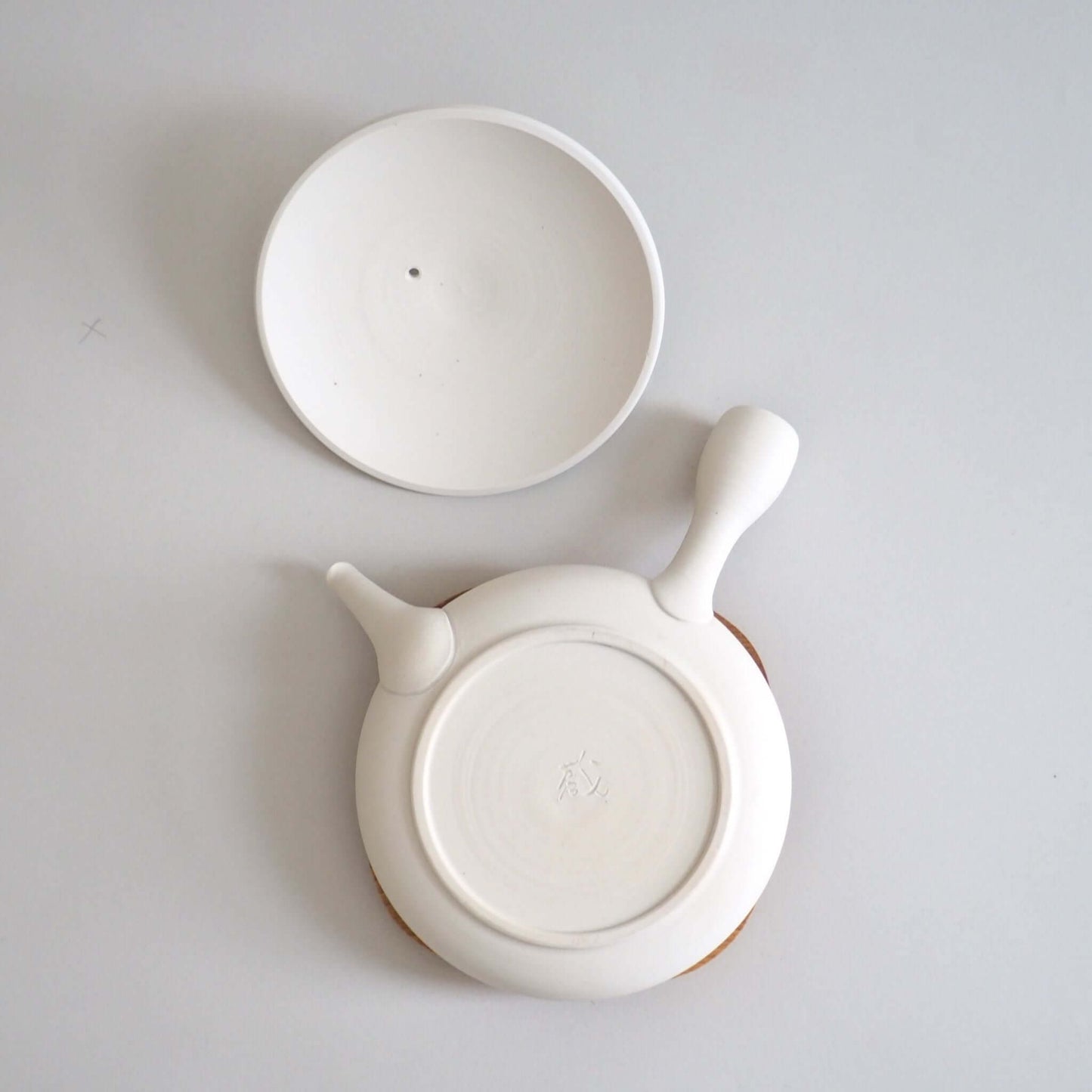 Tokoname ware white flat teapot, viewed from above — soft white appearance achieved through wheel-throwing.