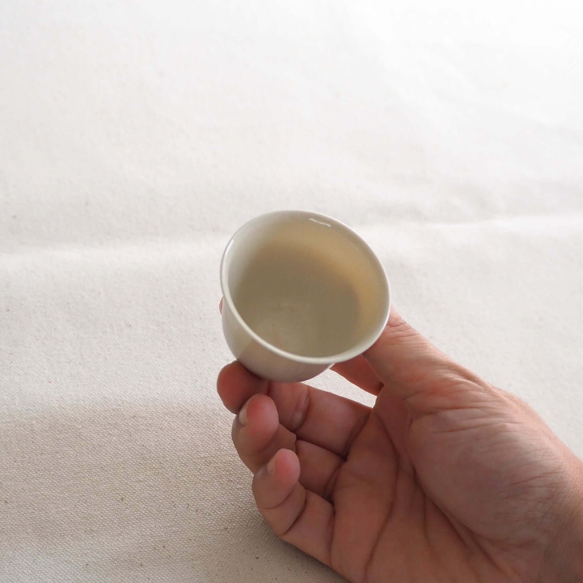 京都柴田窯の中国茶・台湾茶向け白磁茶杯を手で持っている