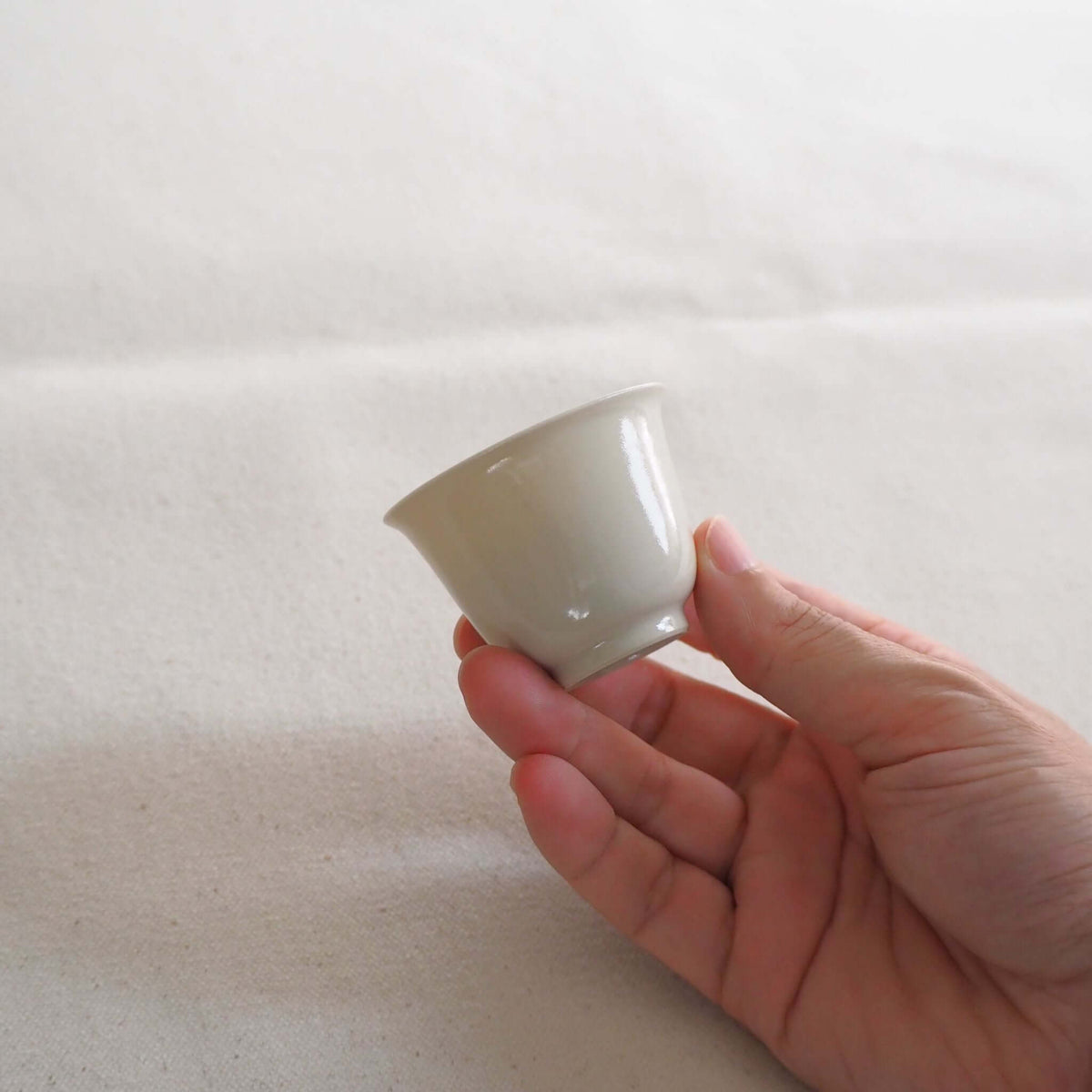 京都柴田窯の中国茶・台湾茶向け白磁茶杯を手で持っている
