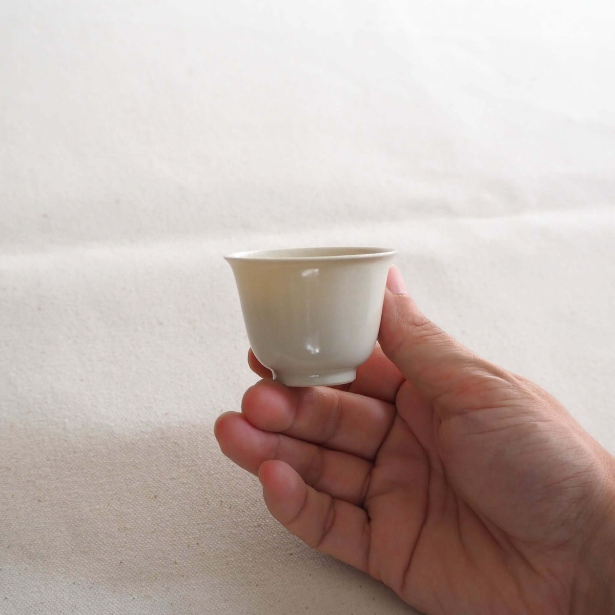 京都柴田窯の中国茶・台湾茶向け白磁茶杯を手で持っている