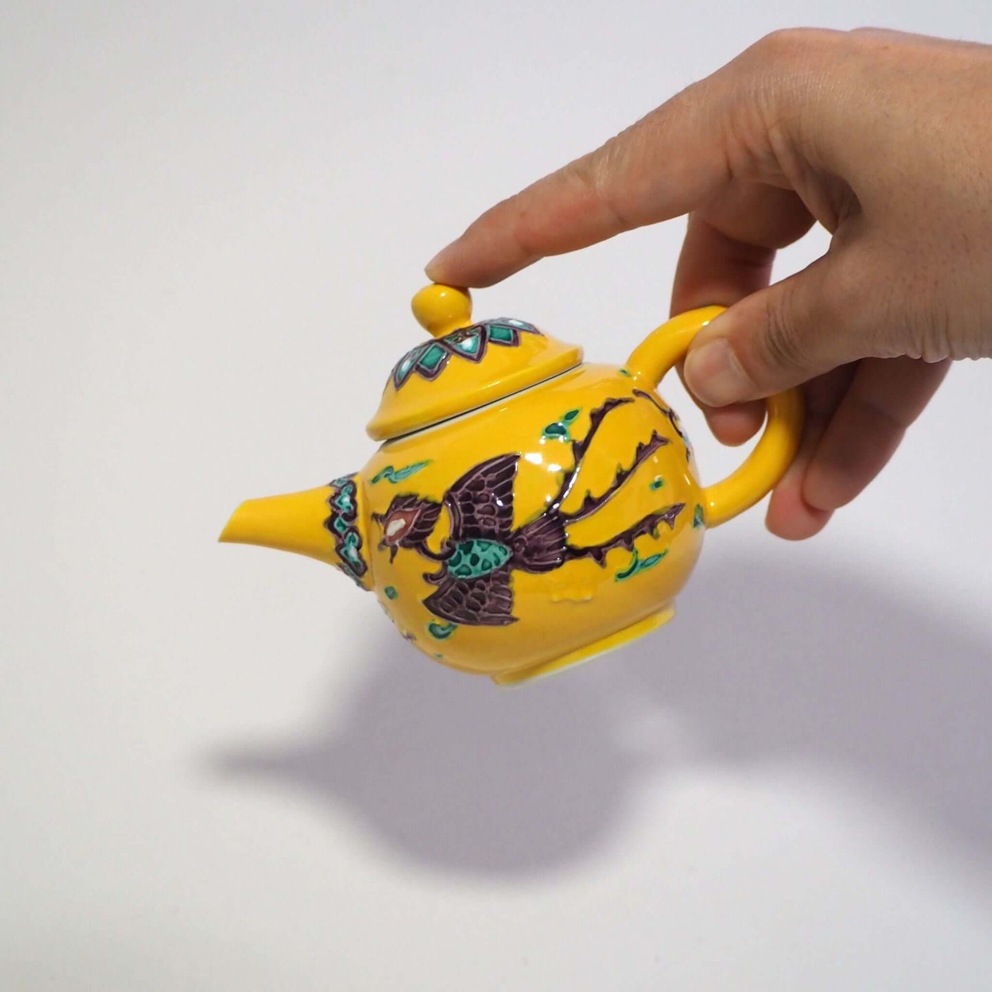 A hand-held kyoyaki Shoami yellow-phoenix phoenix teapot.