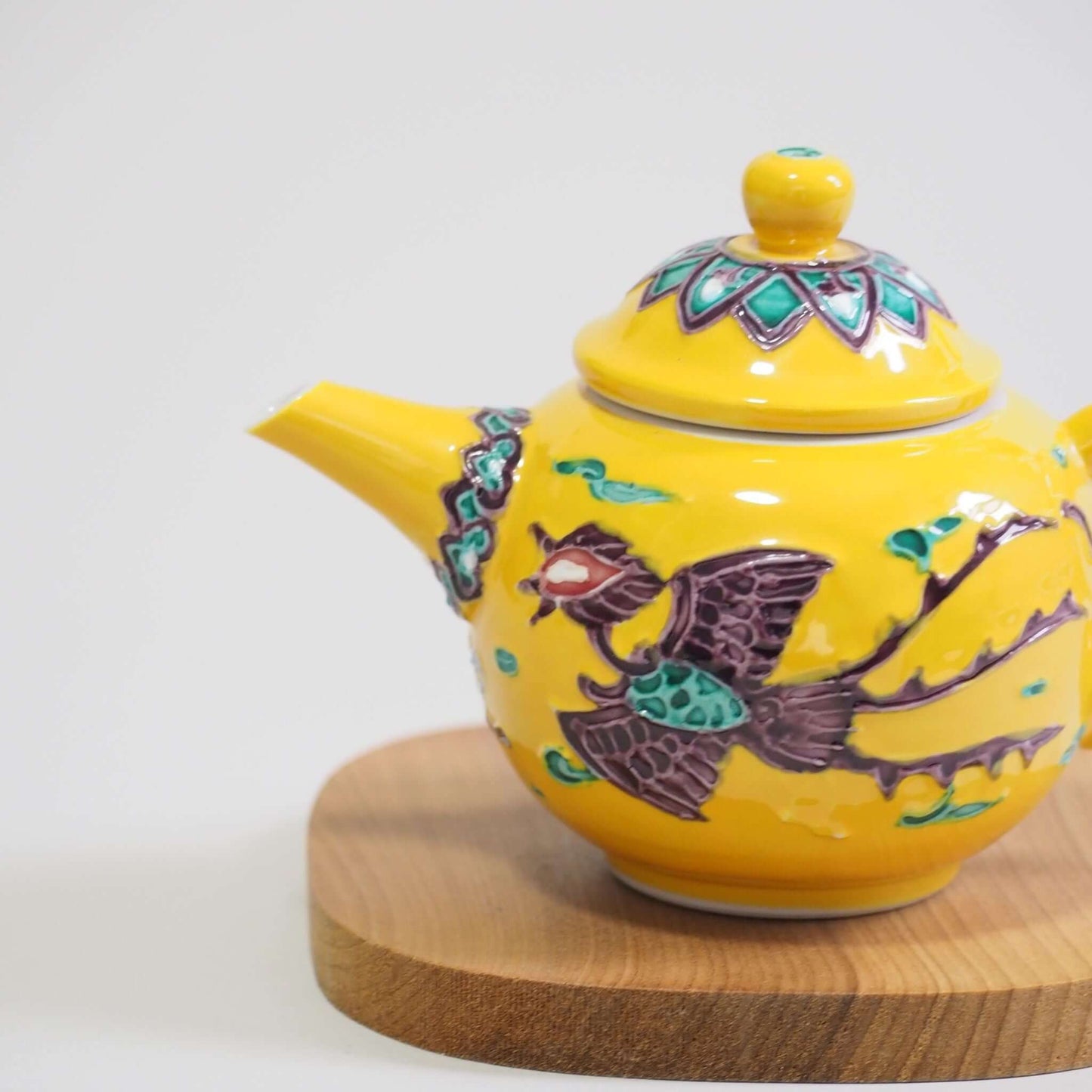A view of the side of the body of a Kyoyaki Shoami yellow-toed phoenix teapot.