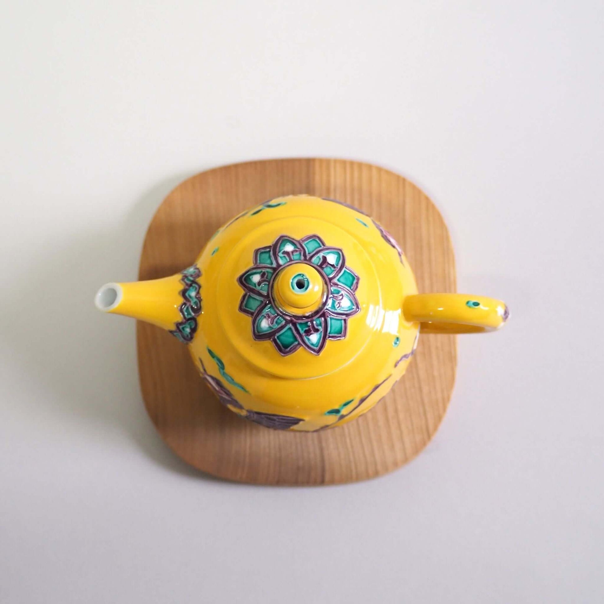 Looking at a Kyo-yaki Shōami yellow-glazed phoenix teapot from directly above.