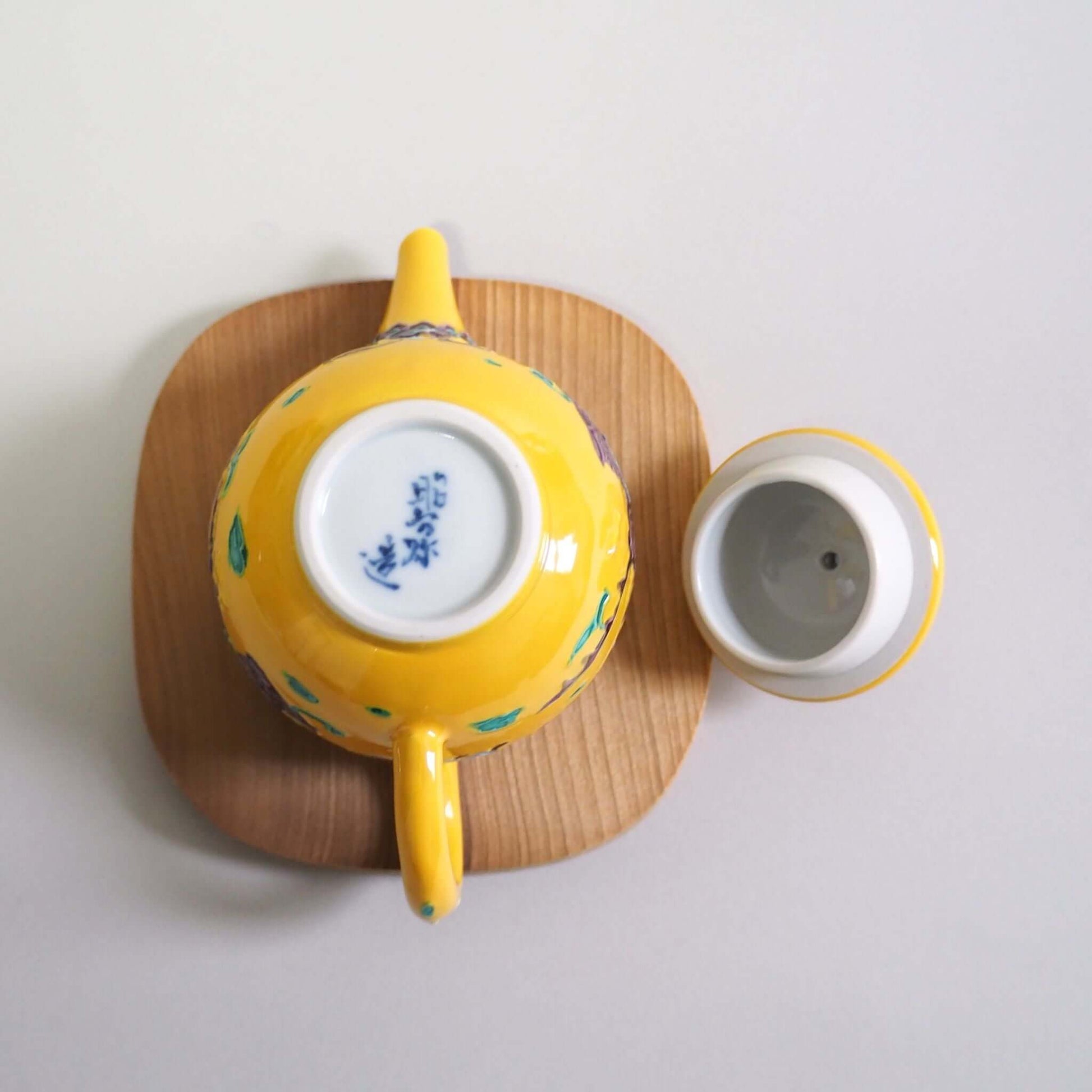 The lid of the Kyoto Ware Shoami yellow-toed phoenix teapot is removed, turned over, and viewed from directly above.