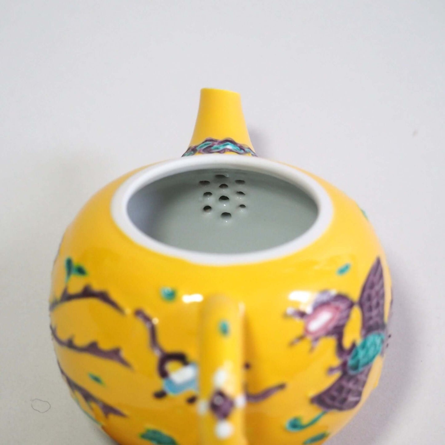 Looking at the tea strainer inside the Kyo-yaki Shoami yellow-toed phoenix teapot.